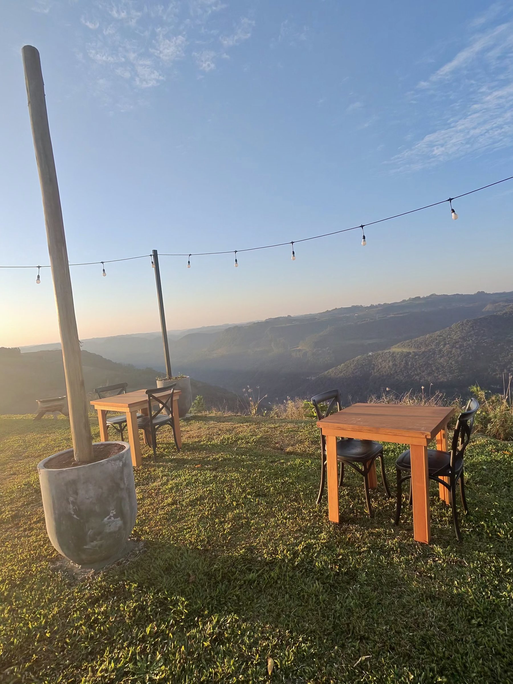 Mesa posta na borda do gramado, com o vale e as montanhas ao fundo